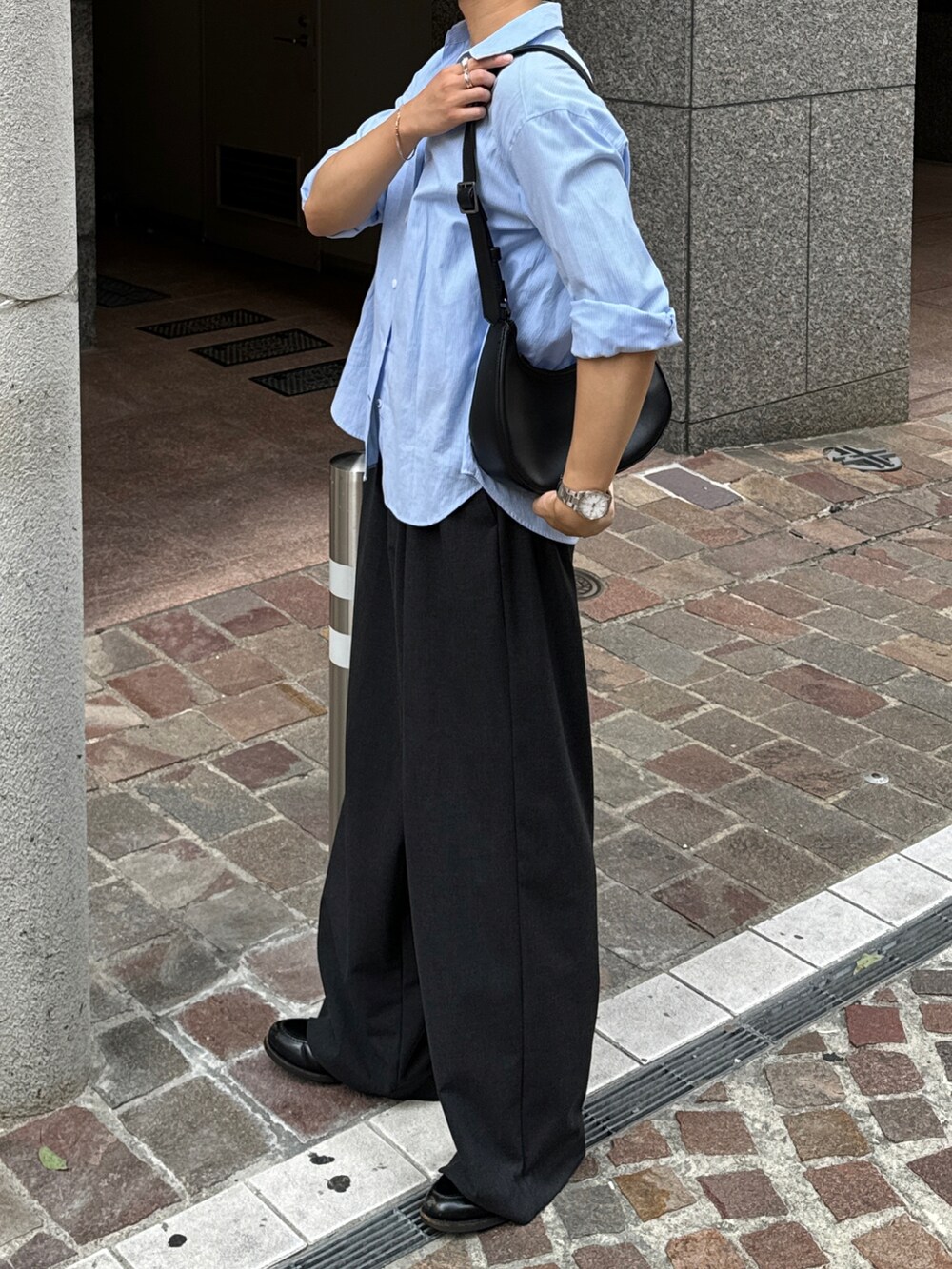 ブラック系のショルダーバッグ、グレー系のスラックス、ブラック系のローファーを着用したメンズの夏コーディネートの5枚目の写真