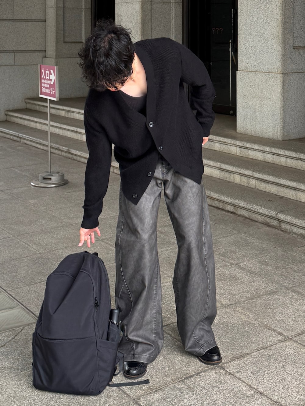 ブラック系のカーディガン/ボレロ、グレー系のパンツ、ブラック系のローファーを着用したメンズの秋コーディネートの3枚目の写真