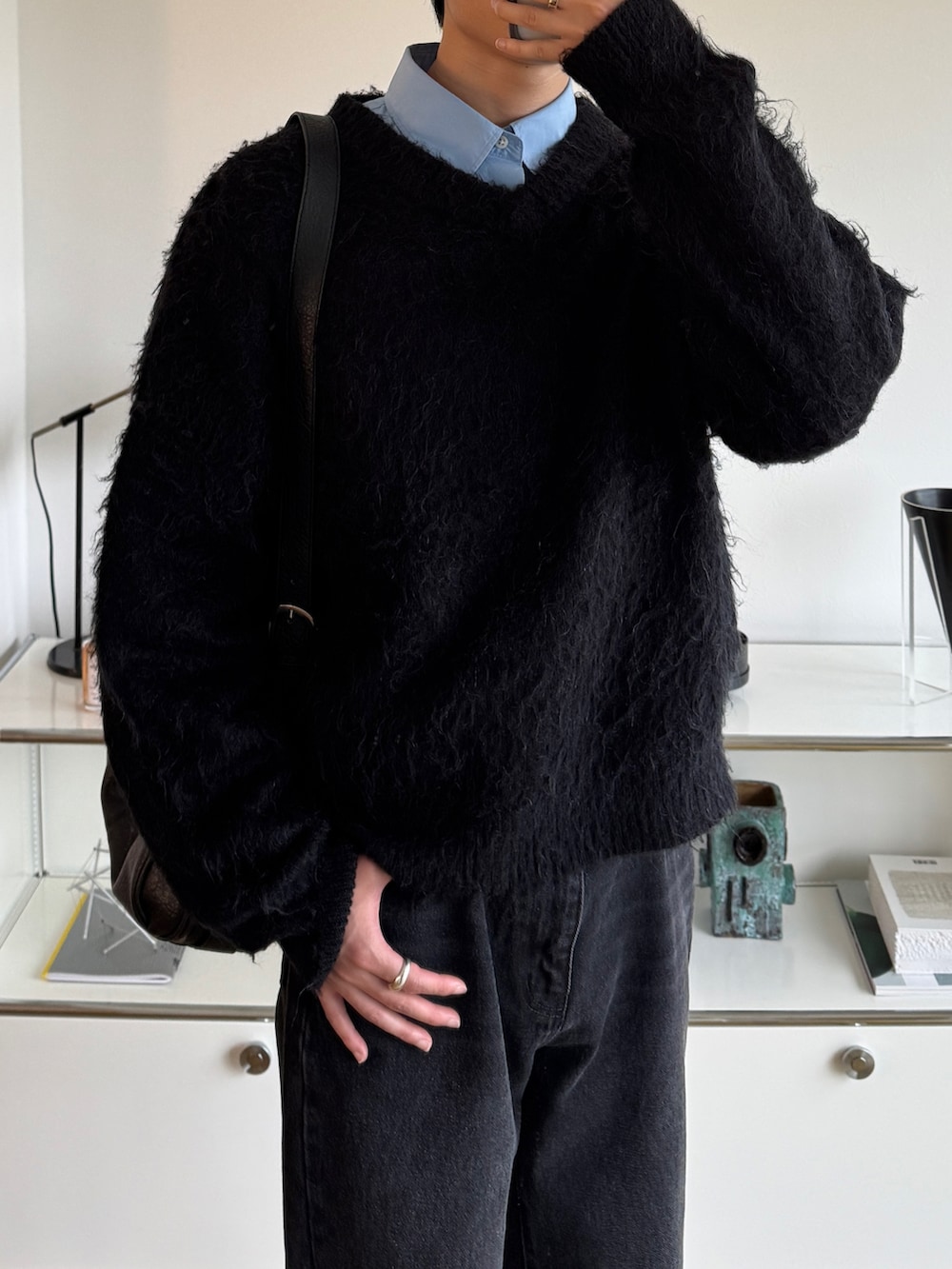 ブラック系のニット/セーター、ブルー系のシャツ/ブラウス、ブラック系のデニムパンツを着用したメンズの秋コーディネートの3枚目の写真