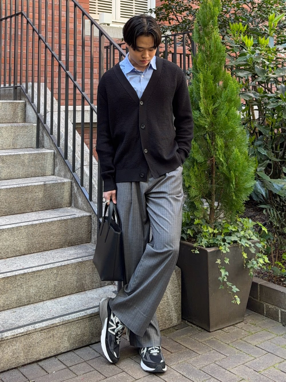 ブルー系のシャツ/ブラウス、グレー系のスラックス、ブラック系のスニーカーを着用したメンズの春コーディネートの2枚目の写真