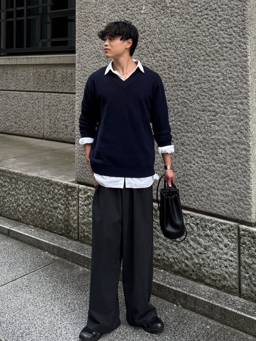 ブラック系のショルダーバッグ、グレー系のスラックス、ブラック系のスニーカーを着用したメンズの秋コーディネートの2枚目の写真