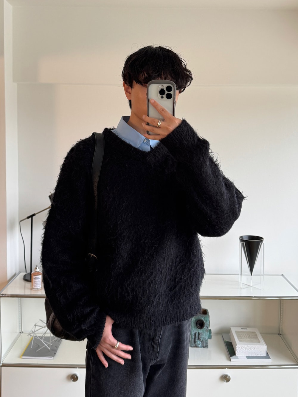 ブラック系のニット/セーター、ブルー系のシャツ/ブラウス、ブラック系のデニムパンツを着用したメンズの秋コーディネートの2枚目の写真