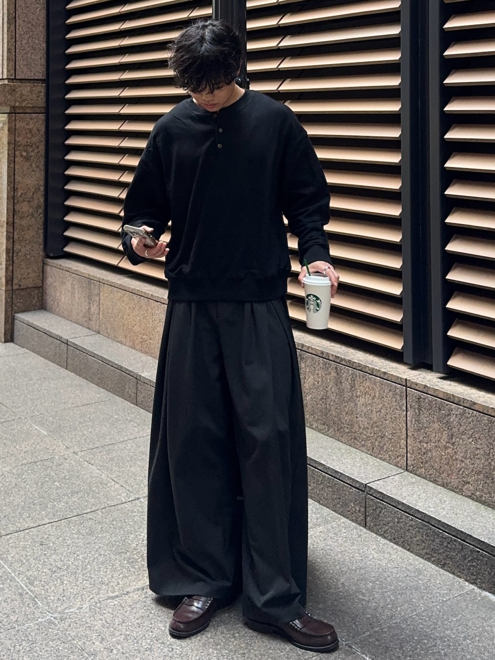 ブラック系のスウェット、グレー系のスラックス、シルバー系のブレスレットを着用したメンズの秋コーディネートの2枚目の写真