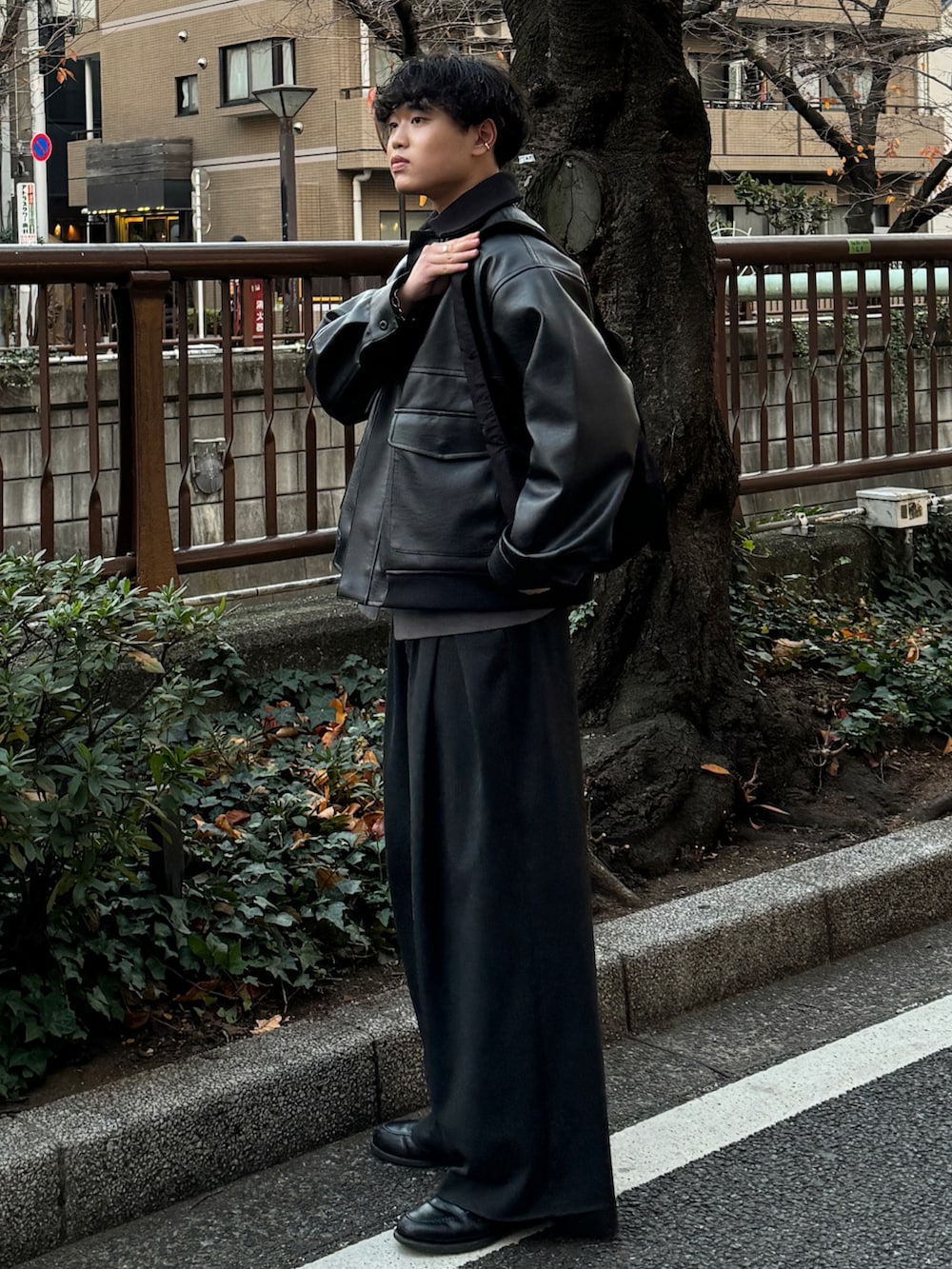 ブラック系のブルゾン、グレー系のニット/セーター、ブラック系のショルダーバッグを着用したメンズの冬コーディネートの2枚目の写真
