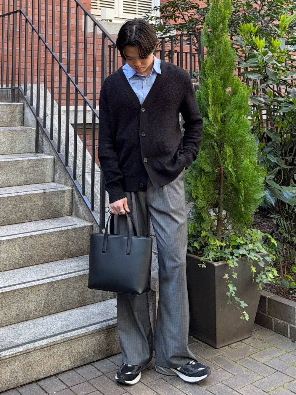 ブルー系のシャツ/ブラウス、グレー系のスラックス、ブラック系のスニーカーを着用したメンズの春コーディネートの3枚目の写真