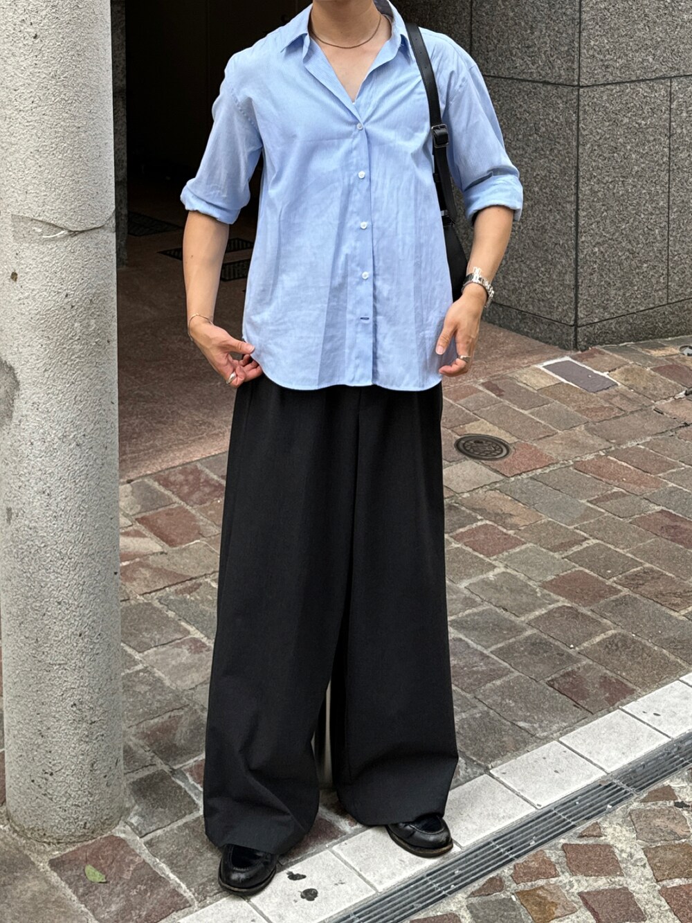 ブラック系のショルダーバッグ、グレー系のスラックス、ブラック系のローファーを着用したメンズの夏コーディネートの3枚目の写真