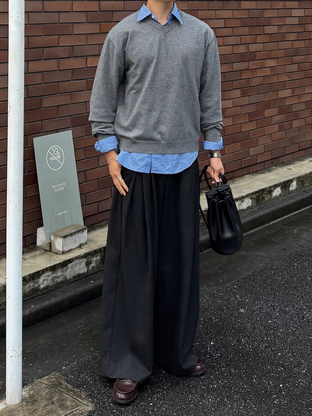 グレー系のニット/セーター、ブルー系のシャツ/ブラウス、ブラック系のショルダーバッグを着用したメンズの秋コーディネートの3枚目の写真