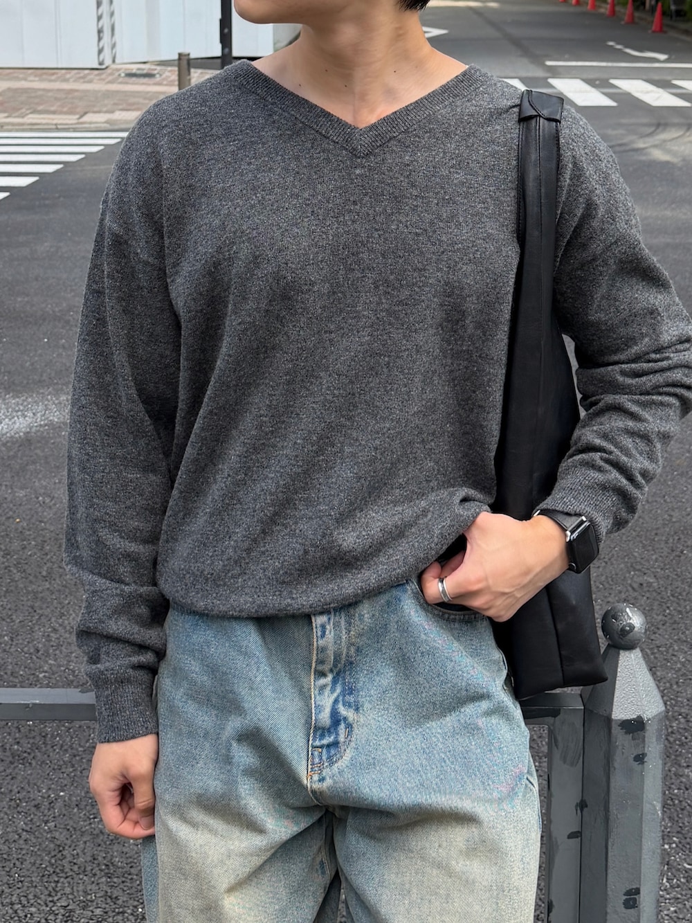 ブルー系のデニムパンツ、ブラック系のドレスシューズ、グレー系のニット/セーターを着用したメンズの秋コーディネートの3枚目の写真