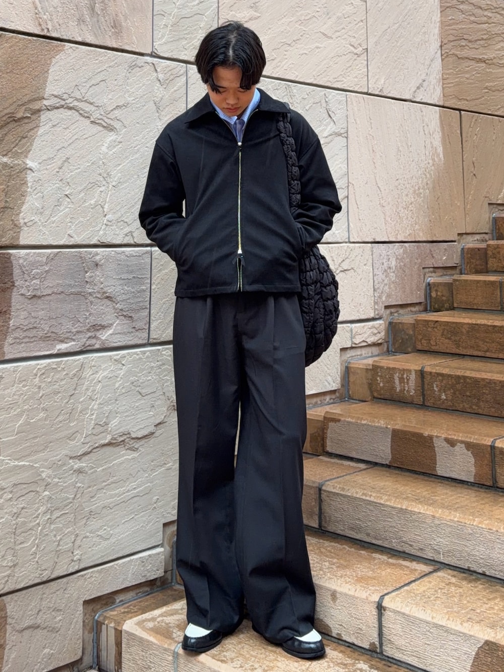 ブラック系のブルゾン、ブラック系のスラックス、その他のローファーを着用したメンズの春コーディネートの3枚目の写真