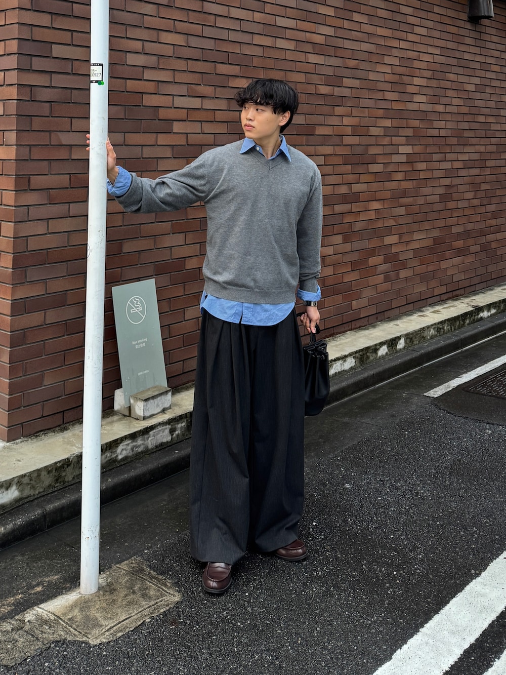 グレー系のニット/セーター、ブルー系のシャツ/ブラウス、ブラック系のショルダーバッグを着用したメンズの秋コーディネートの2枚目の写真