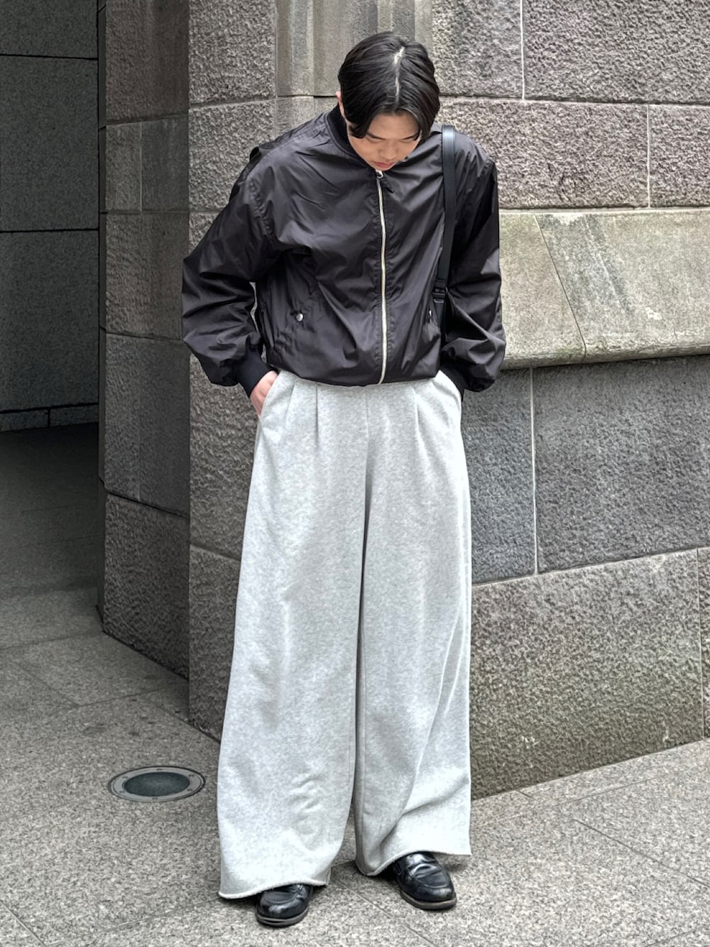 ブラック系のMA-1、グレー系のスウェットパンツ、ブラック系のローファーを着用したメンズの春コーディネートの2枚目の写真
