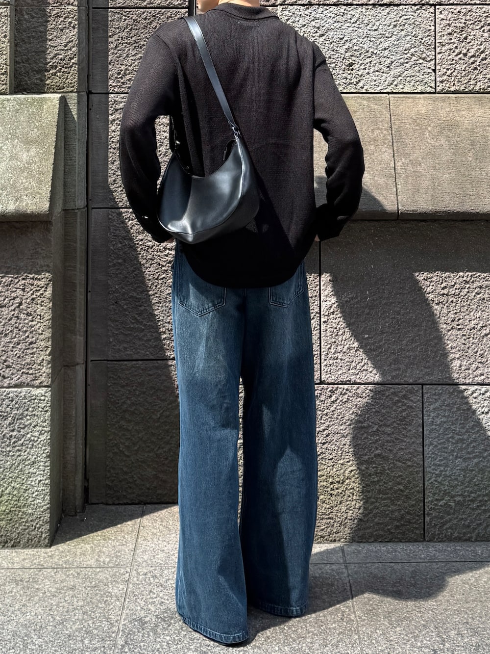 ブルー系のデニムパンツ、ブラック系のローファー、ブラック系のショルダーバッグを着用したメンズの秋コーディネートの2枚目の写真