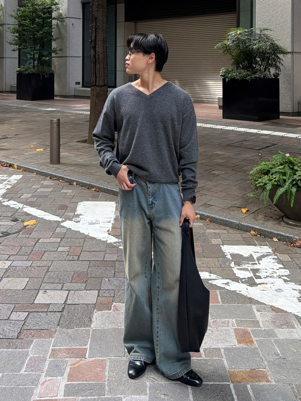 ブルー系のデニムパンツ、ブラック系のドレスシューズ、グレー系のニット/セーターを着用したメンズの秋コーディネートの2枚目の写真