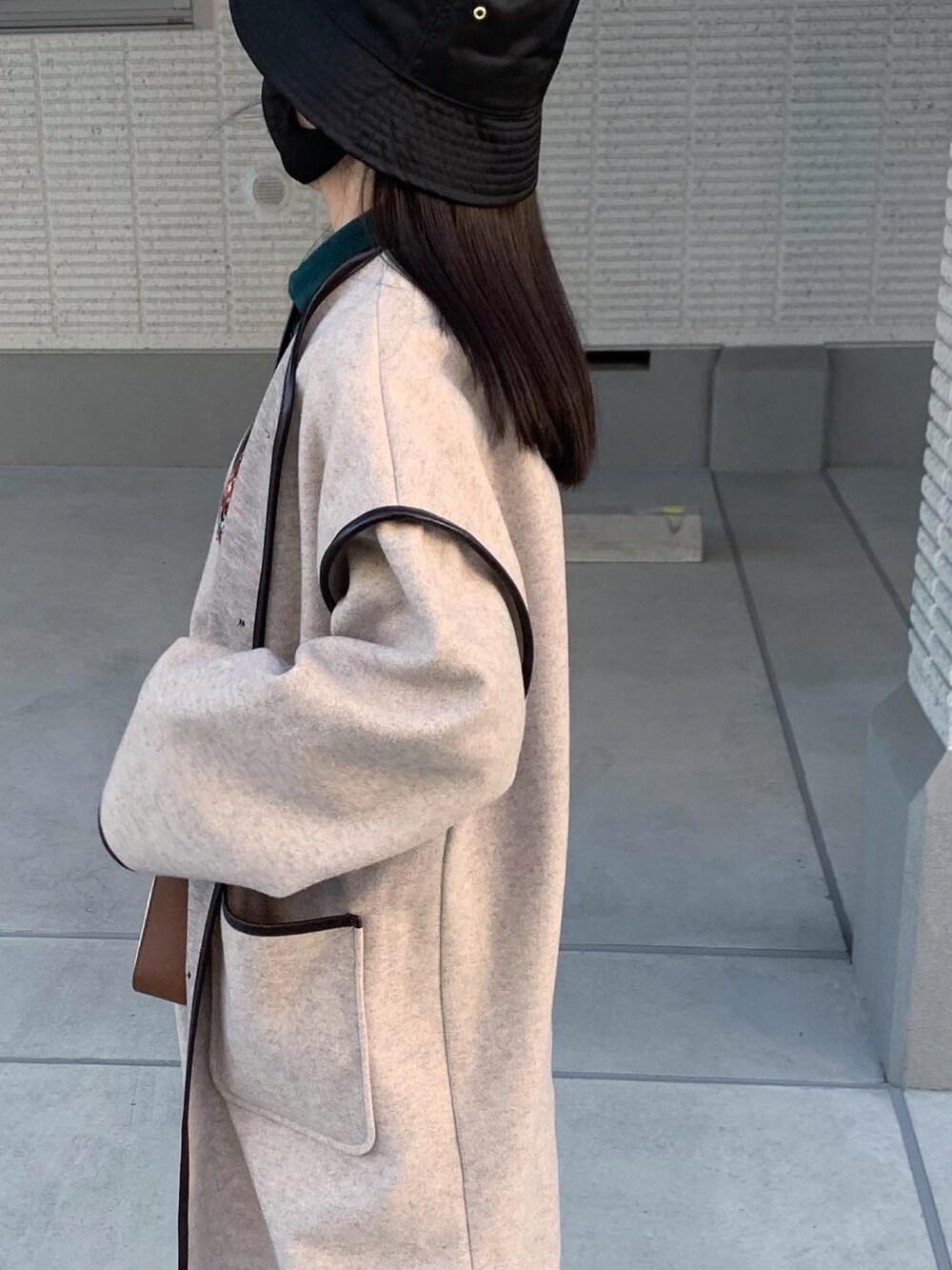 ブラック系のスニーカー、ベージュ系のノーカラージャケット、ブラック系のハットを着用したレディースの冬コーディネートの3枚目の写真