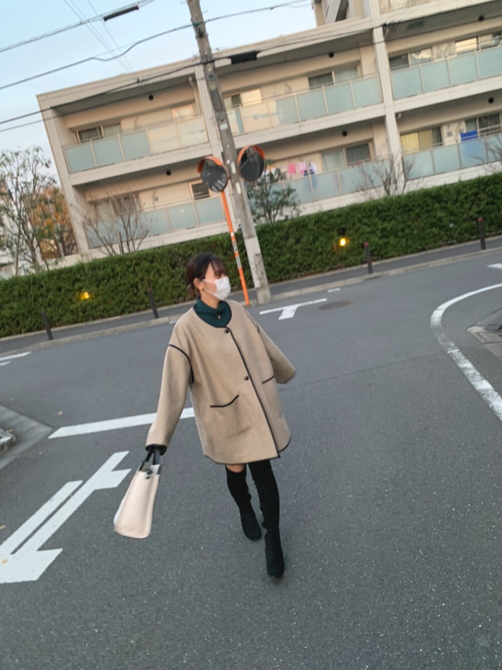 ホワイト系のハンドバッグ、ベージュ系のその他アウター、グリーン系のニット/セーターを着用したレディースの冬コーディネートの3枚目の写真