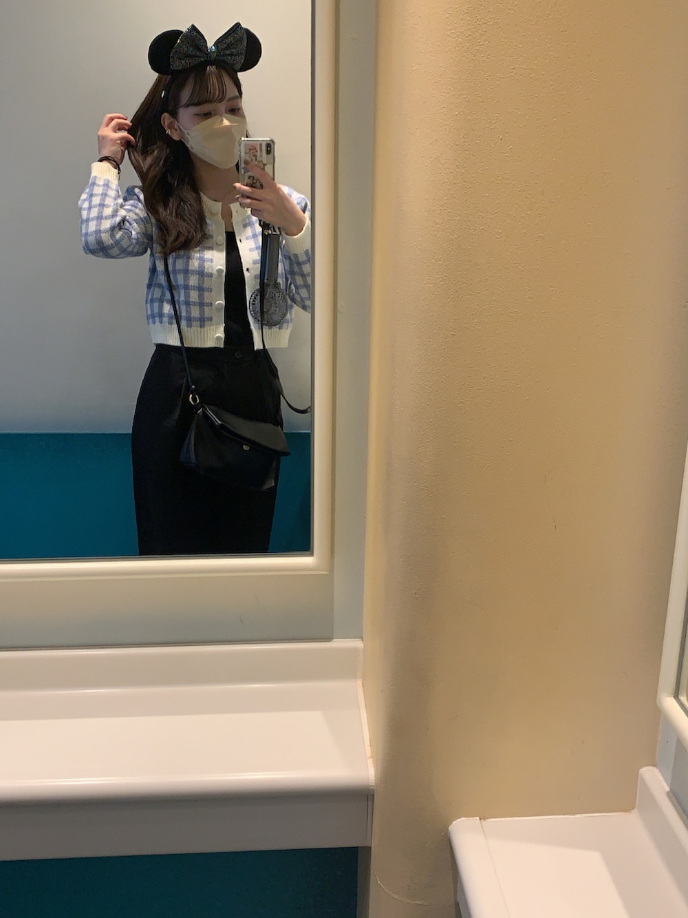 ブラック系のスラックス、ブラック系のバッグ、ブルー系のニット/セーターを着用したレディースの冬コーディネートの2枚目の写真