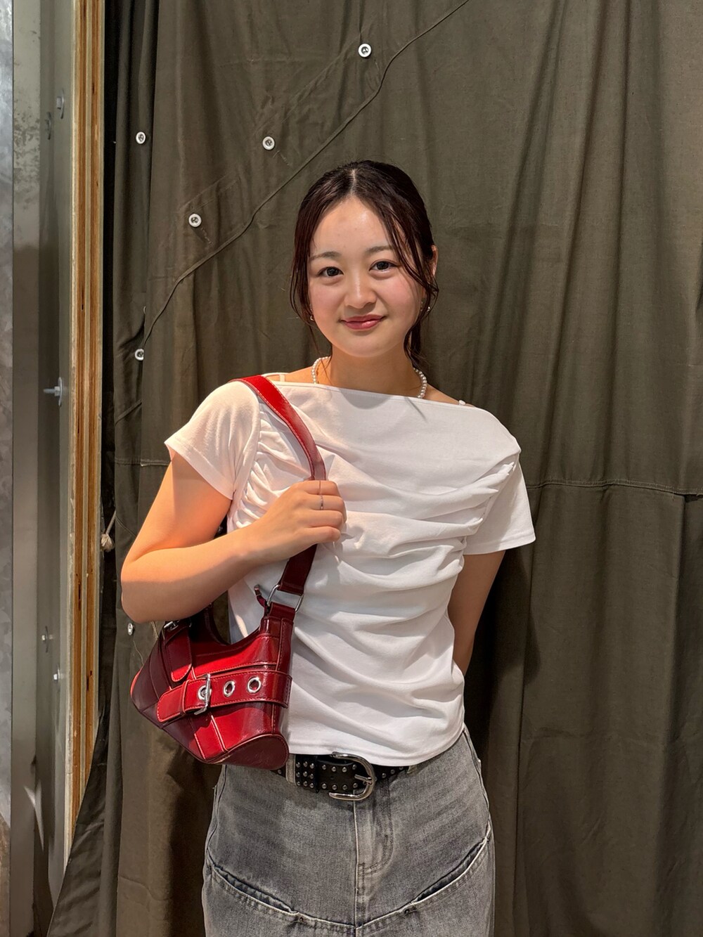 ホワイト系のTシャツ/カットソー、グレー系のデニムパンツ、レッド系のショルダーバッグを着用したレディースの春コーディネートの3枚目の写真