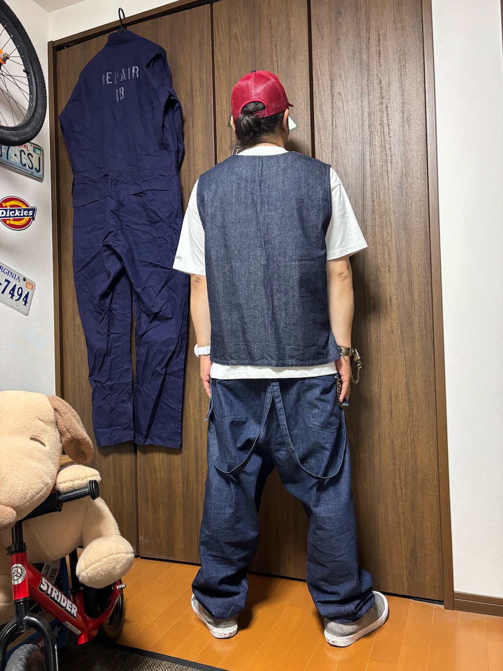 ブルー系のベスト、ブルー系のデニムパンツ、グレー系のスニーカーを着用したメンズの春コーディネートの2枚目の写真