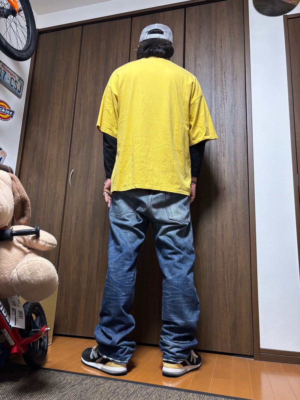 イエロー系のTシャツ/カットソー、ブルー系のデニムパンツ、ブラック系のスニーカーを着用したメンズの夏コーディネートの2枚目の写真