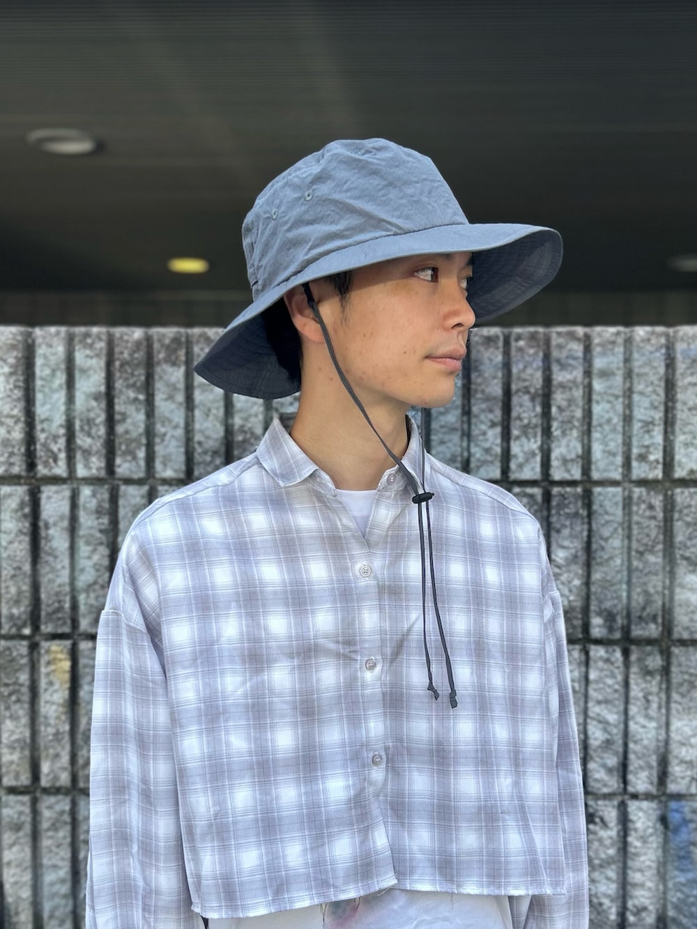 グレー系のハットを着用したメンズの夏コーディネートの2枚目の写真