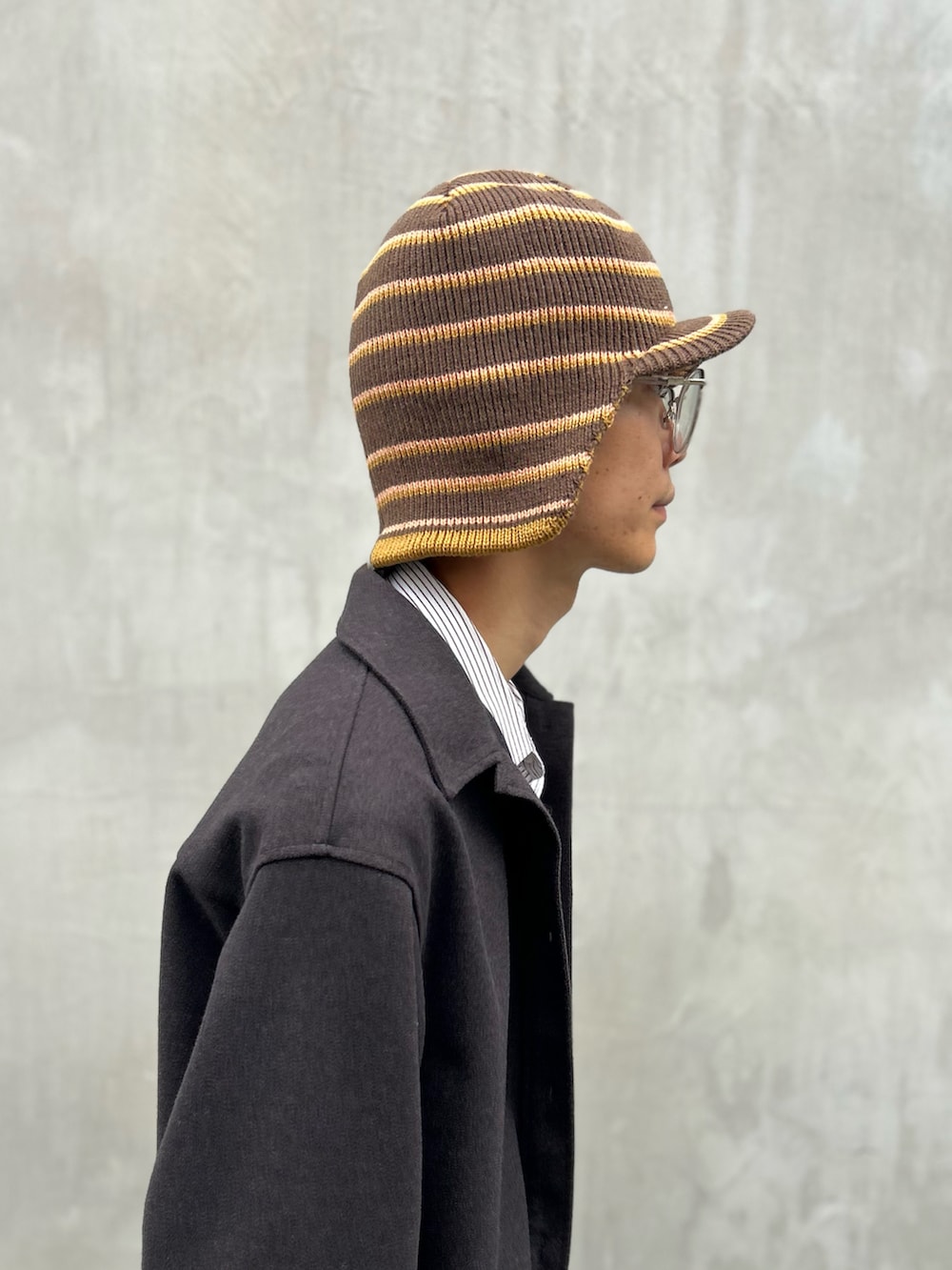 ブラウン系のキャップを着用したメンズの秋コーディネートの4枚目の写真