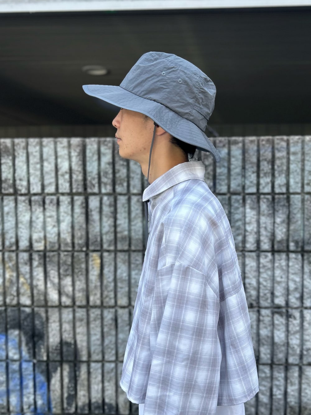 グレー系のハットを着用したメンズの夏コーディネートの3枚目の写真