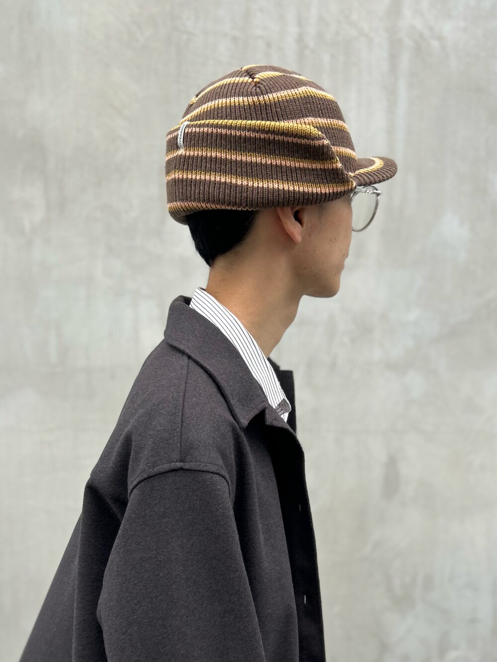ブラウン系のキャップを着用したメンズの秋コーディネートの2枚目の写真