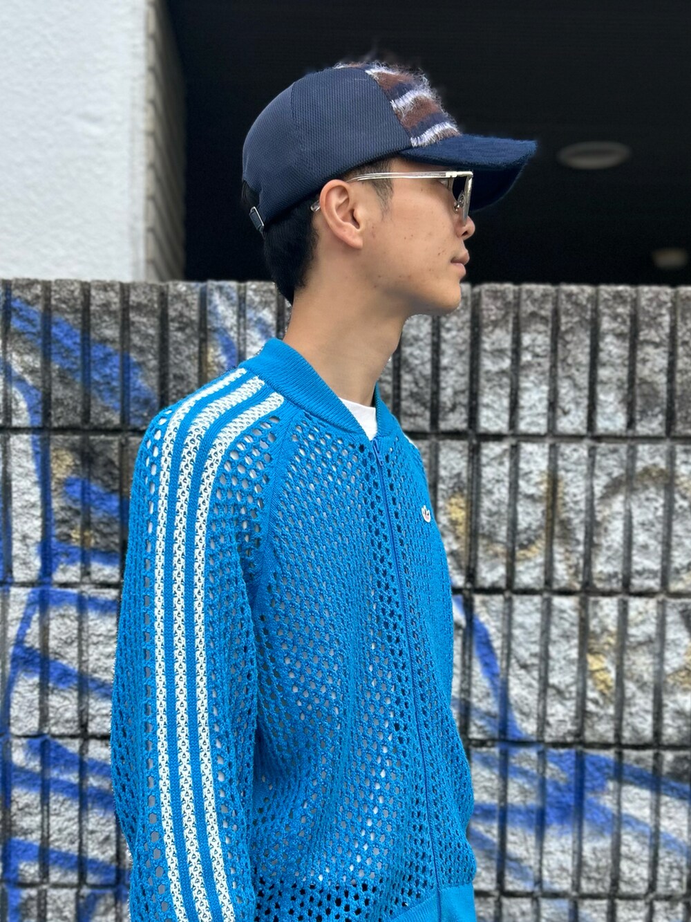 ブルー系のキャップを着用したメンズの秋コーディネートの2枚目の写真