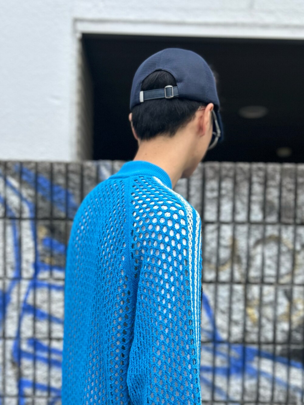 ブルー系のキャップを着用したメンズの秋コーディネートの5枚目の写真