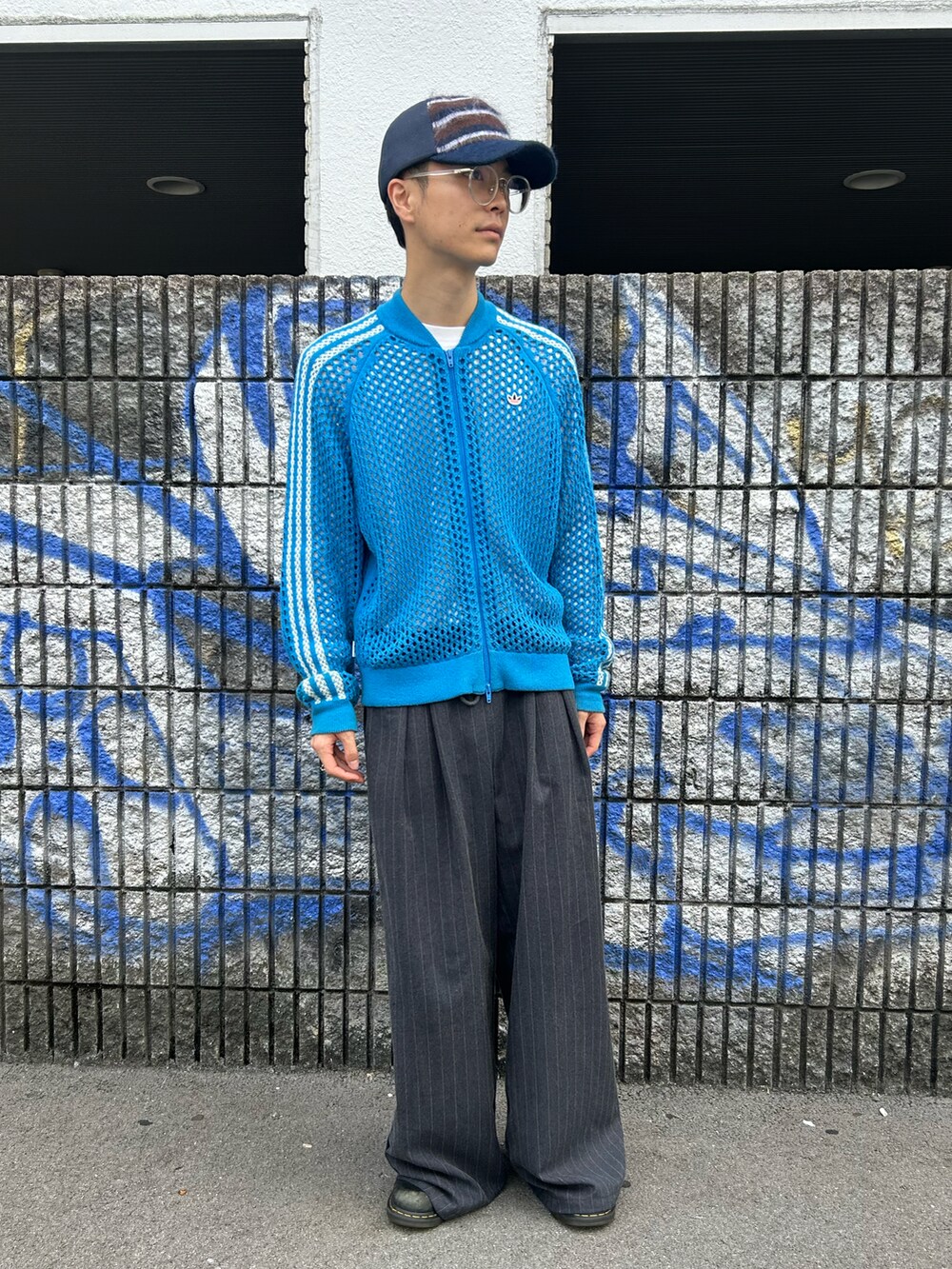 ブルー系のキャップを着用したメンズの秋コーディネートの3枚目の写真