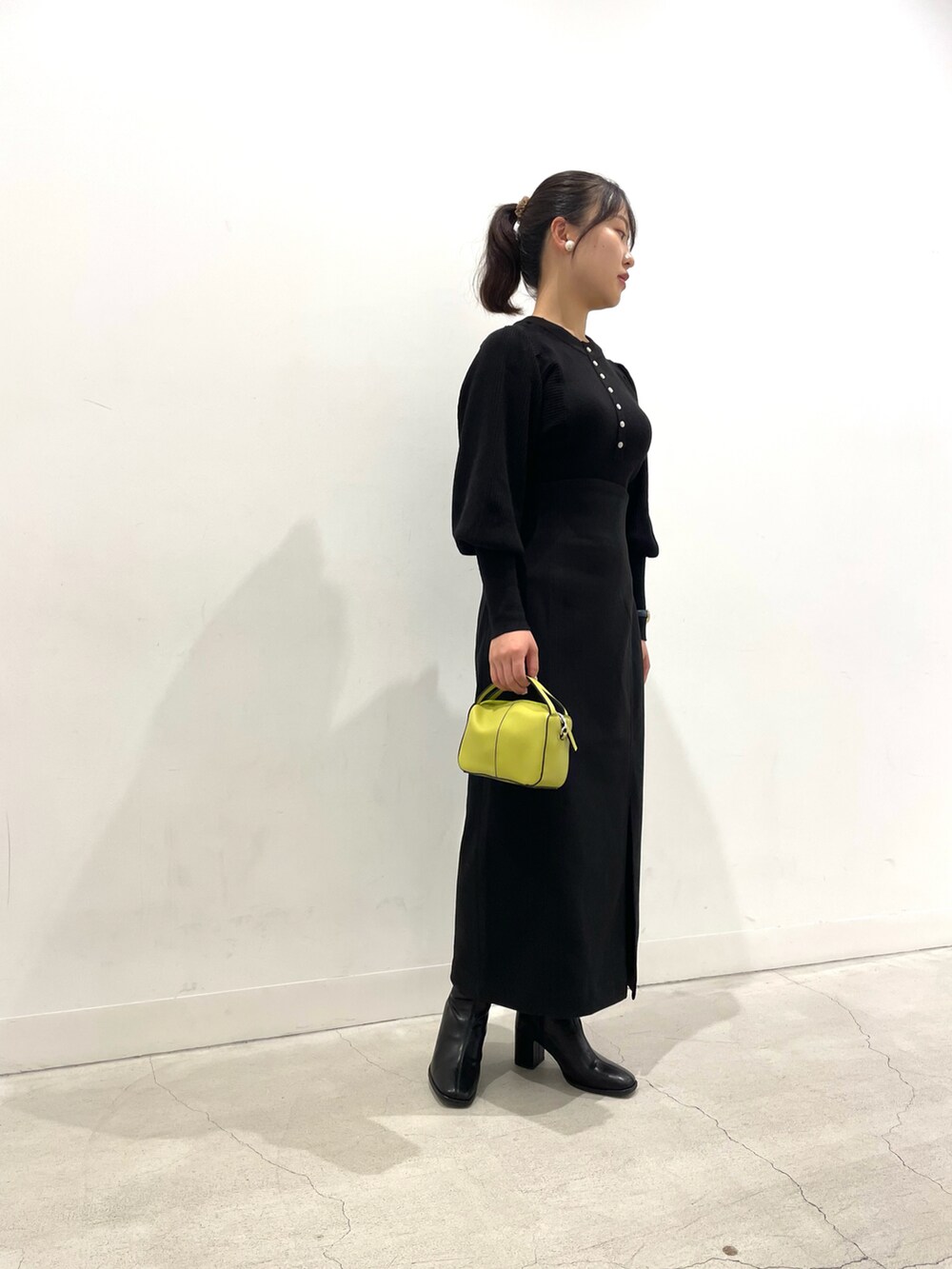 ブラック系のニット/セーター、ブラック系のスカート、ブラック系のブーツを着用したレディースの秋コーディネートの2枚目の写真