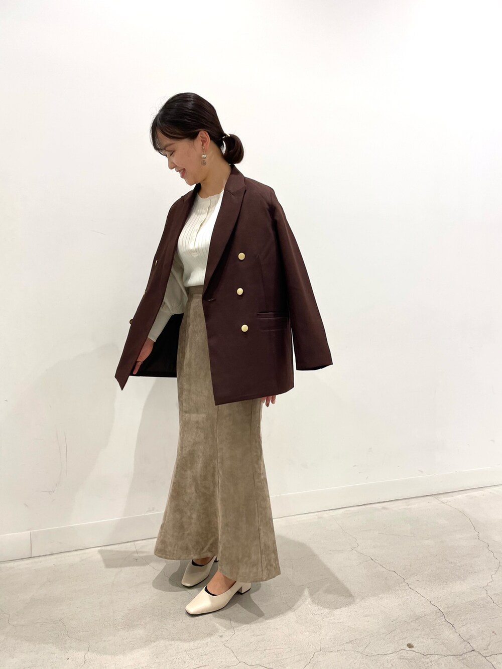 ブラウン系のその他アウター、ホワイト系のニット/セーター、ホワイト系のショルダーバッグを着用したレディースの秋コーディネートの2枚目の写真