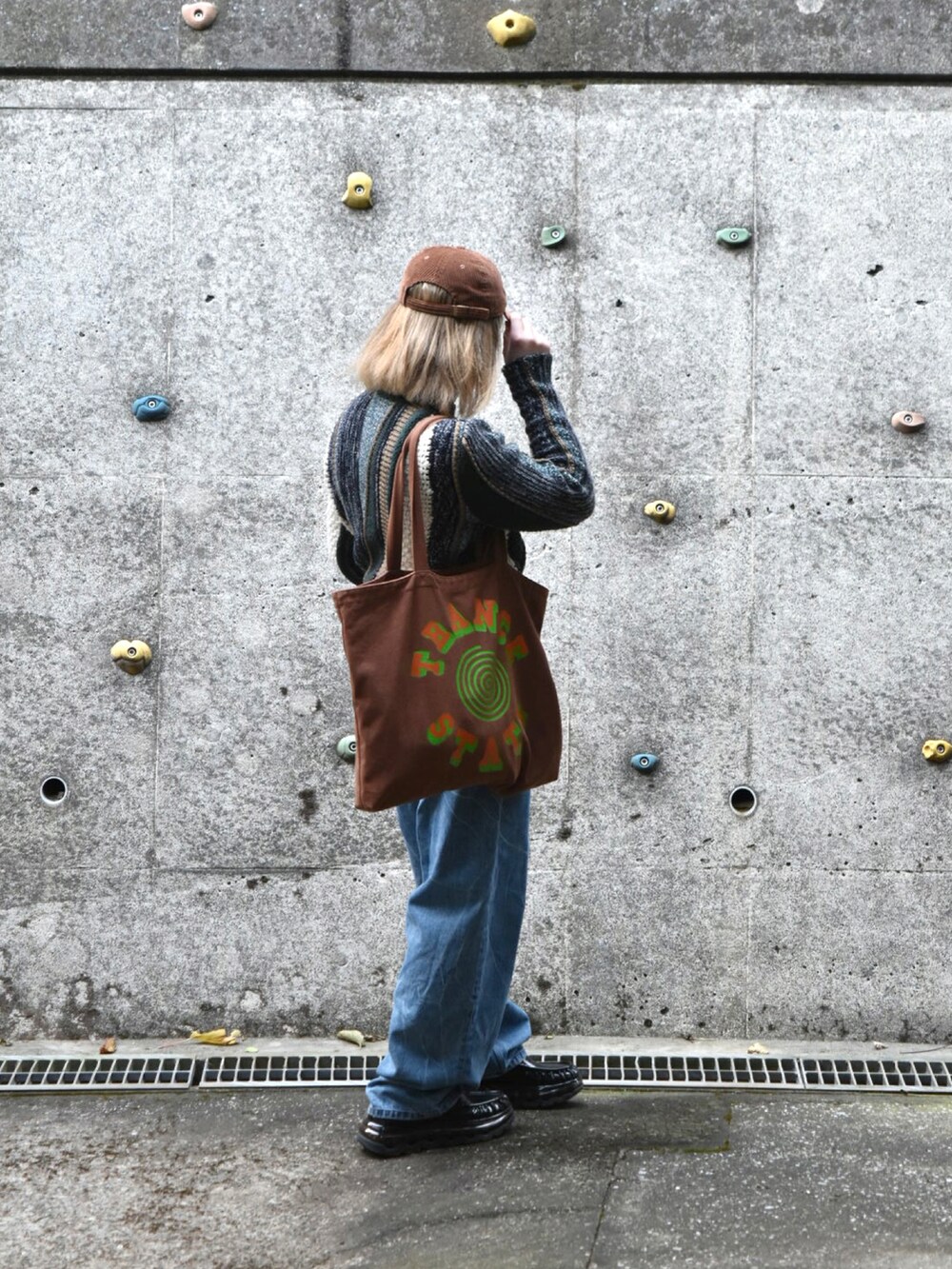 グリーン系のニット/セーター、ブルー系のデニムパンツ、ブラック系のローファーを着用したメンズの冬コーディネートの2枚目の写真