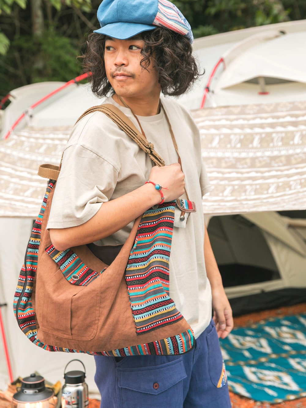 ブラウン系のショルダーバッグ、ベージュ系のTシャツ/カットソー、ブルー系のその他パンツを着用したメンズの春コーディネートの4枚目の写真