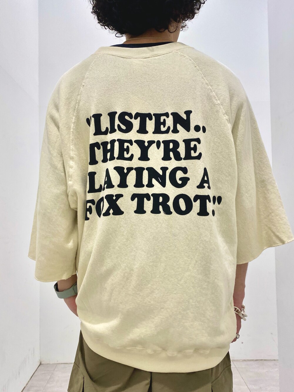 ベージュ系のTシャツ/カットソー、グリーン系のカーゴパンツを着用したメンズの夏コーディネートの3枚目の写真
