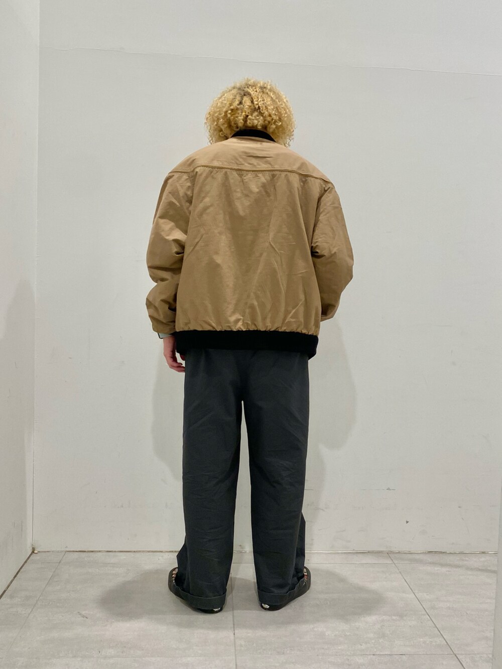 ベージュ系のブルゾン、オレンジ系のTシャツ/カットソーを着用したメンズの秋コーディネートの3枚目の写真