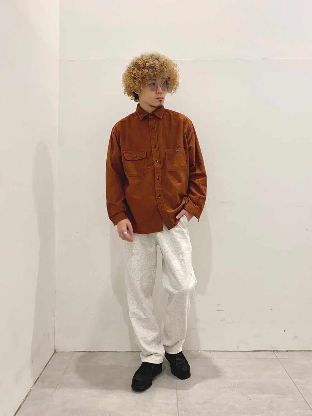 グリーン系のミリタリージャケット、ブラウン系のシャツ/ブラウス、ホワイト系のスウェットパンツを着用したメンズの秋コーディネートの2枚目の写真