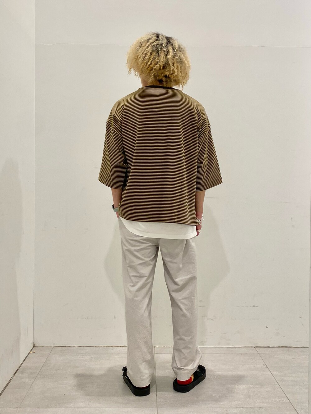 ブラウン系のTシャツ/カットソー、グレー系のパンツを着用したメンズの春コーディネートの3枚目の写真