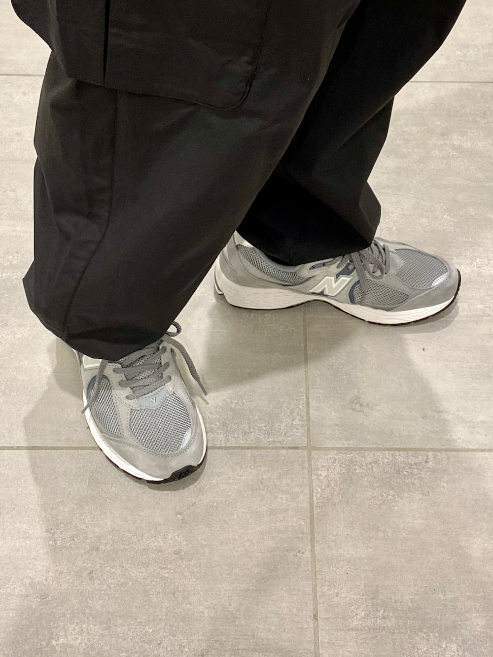 グリーン系のマウンテンパーカー、ブラック系のカーゴパンツ、グレー系のスニーカーを着用したメンズの春コーディネートの4枚目の写真