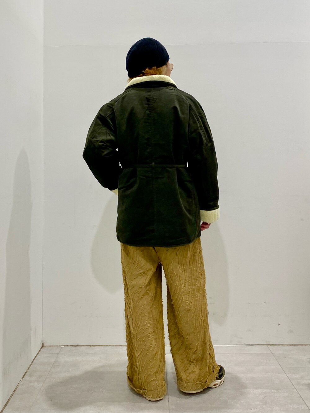 グレー系のニット/セーター、グリーン系のブルゾンを着用したメンズの冬コーディネートの2枚目の写真