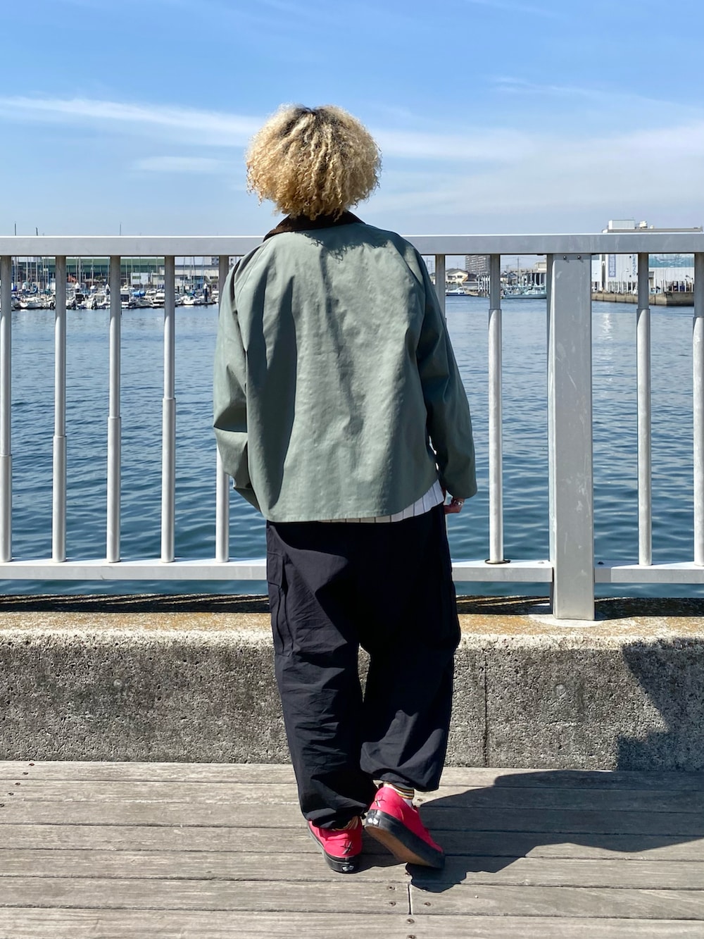 グリーン系のブルゾン、ベージュ系のシャツ/ブラウス、ブラック系のカーゴパンツを着用したメンズの春コーディネートの2枚目の写真