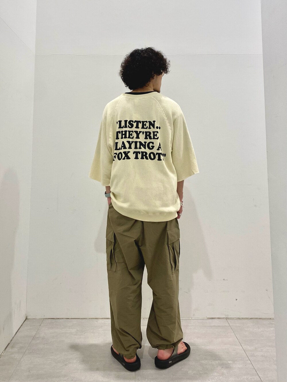 ベージュ系のTシャツ/カットソー、グリーン系のカーゴパンツを着用したメンズの夏コーディネートの2枚目の写真