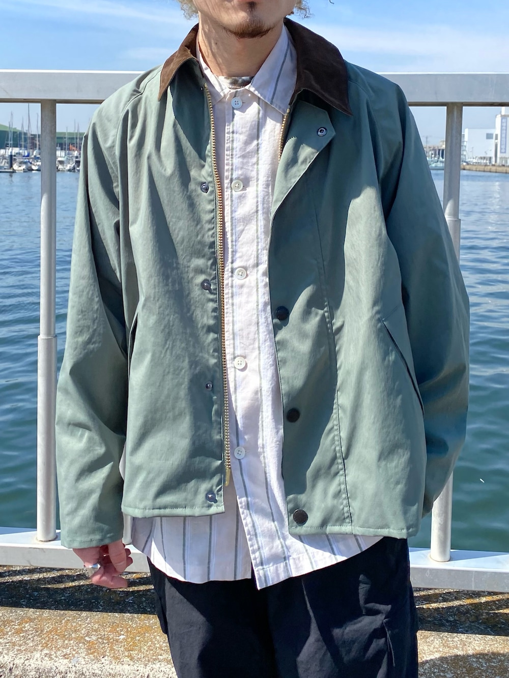 グリーン系のブルゾン、ベージュ系のシャツ/ブラウス、ブラック系のカーゴパンツを着用したメンズの春コーディネートの3枚目の写真