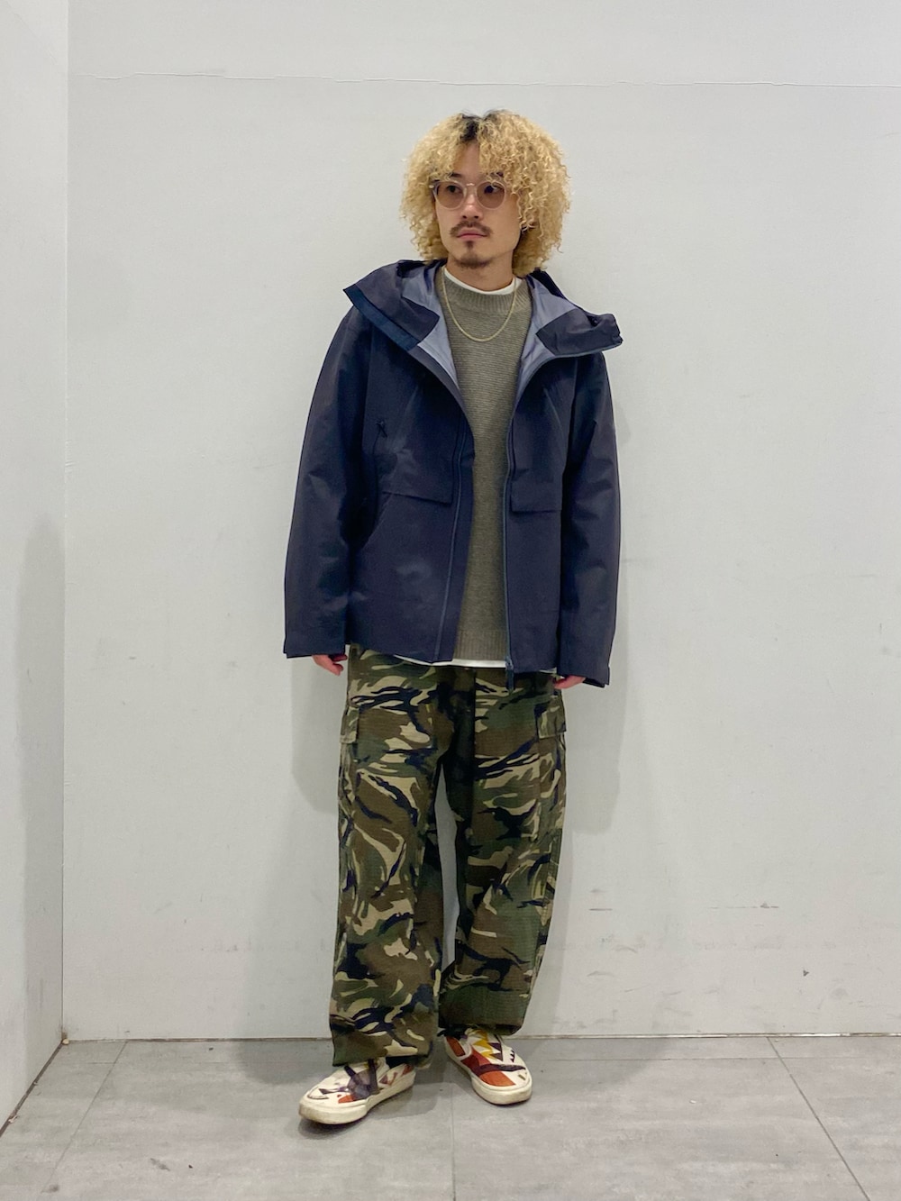 ブラック系のマウンテンパーカー、グレー系のニット/セーター、グリーン系のカーゴパンツを着用したメンズの秋コーディネートの2枚目の写真