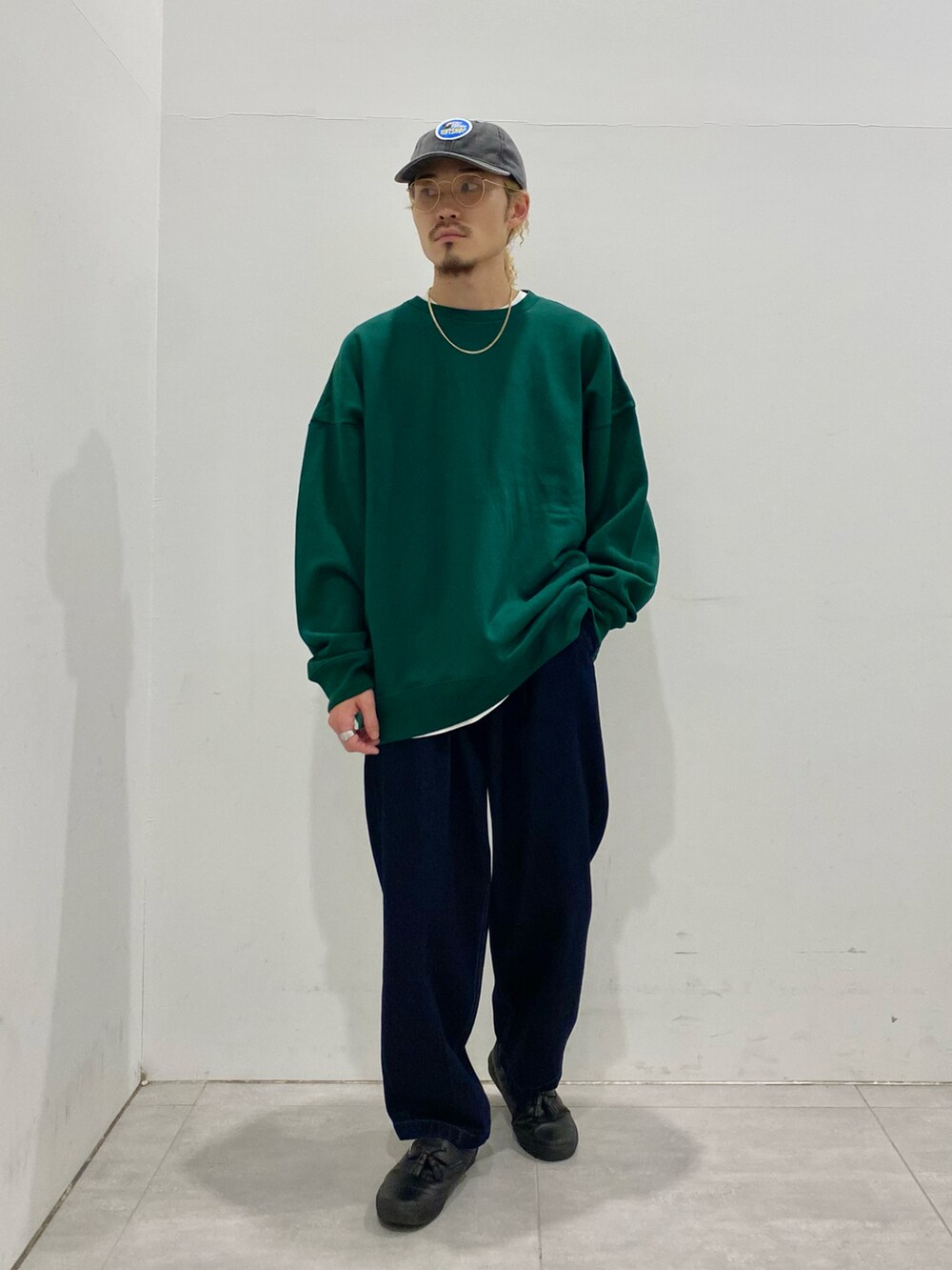 グリーン系のスウェット、ブルー系のデニムパンツを着用したメンズの秋コーディネートの2枚目の写真