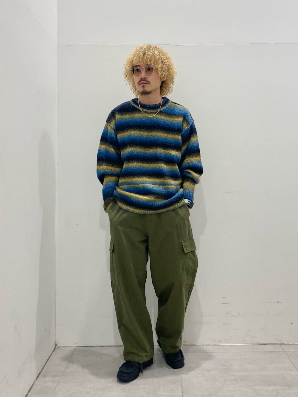 ブルー系のMA-1、ブルー系のニット/セーター、グリーン系のカーゴパンツを着用したメンズの秋コーディネートの4枚目の写真