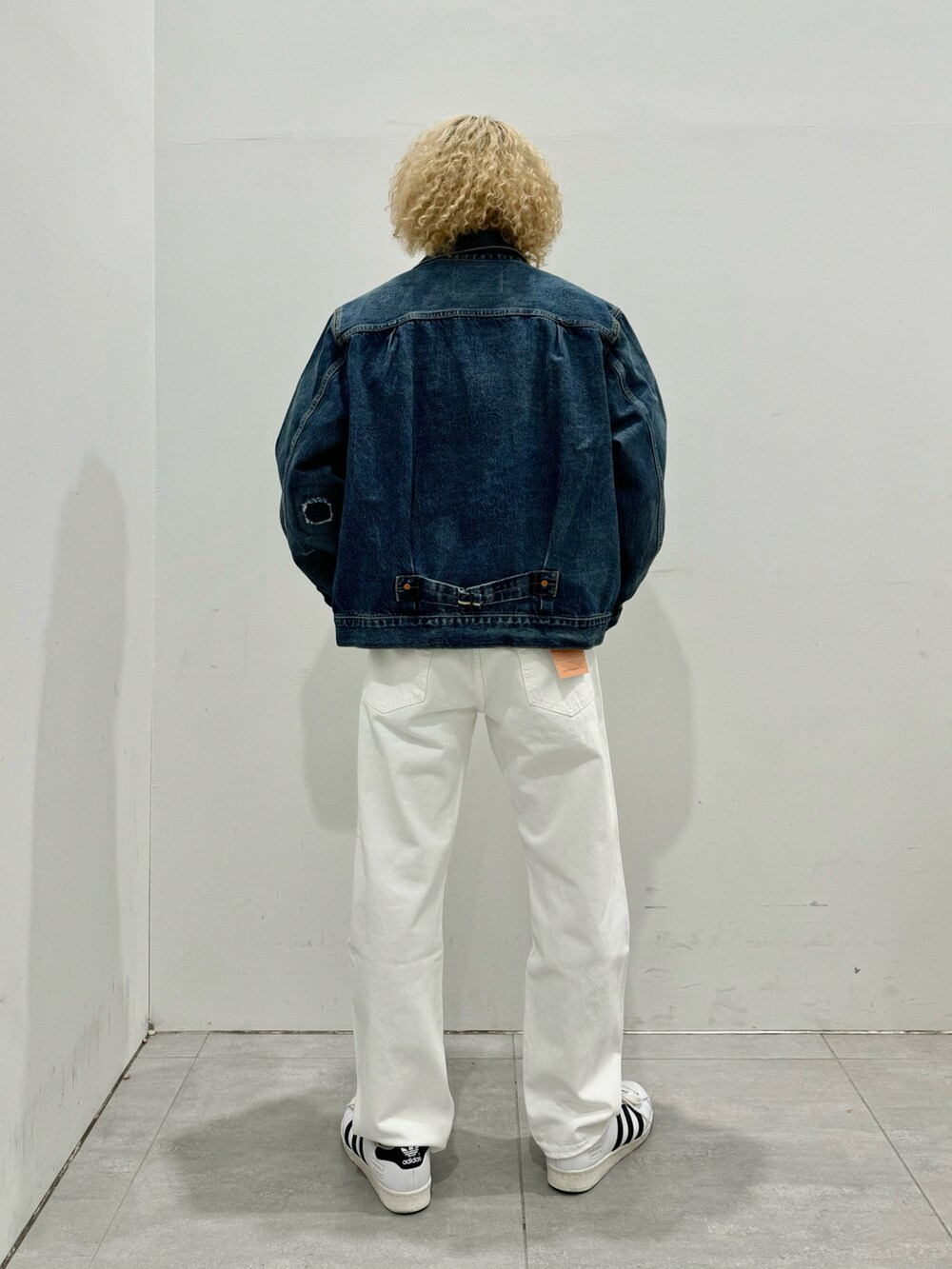 ブルー系のデニムジャケット、ホワイト系のデニムパンツ、ホワイト系のスニーカーを着用したメンズの冬コーディネートの2枚目の写真