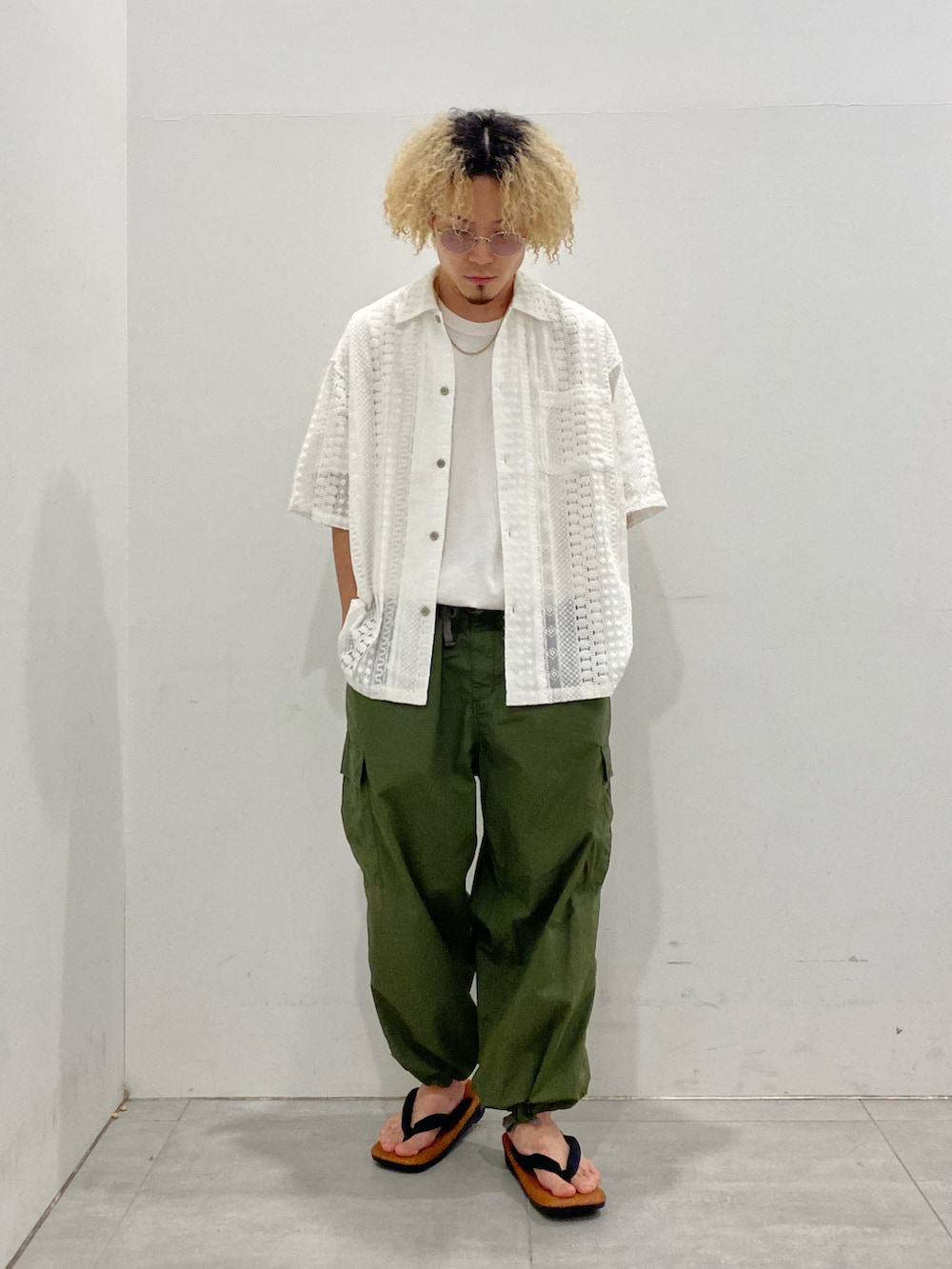 ホワイト系のシャツ/ブラウス、グリーン系のカーゴパンツ、ブラウン系のサンダルを着用したメンズの春コーディネートの2枚目の写真