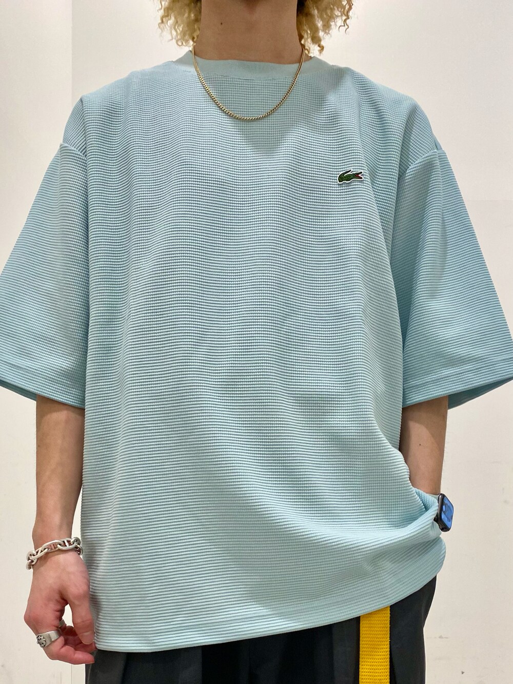 グリーン系のTシャツ/カットソー、ブラック系のチノパンツを着用したメンズの夏コーディネートの3枚目の写真