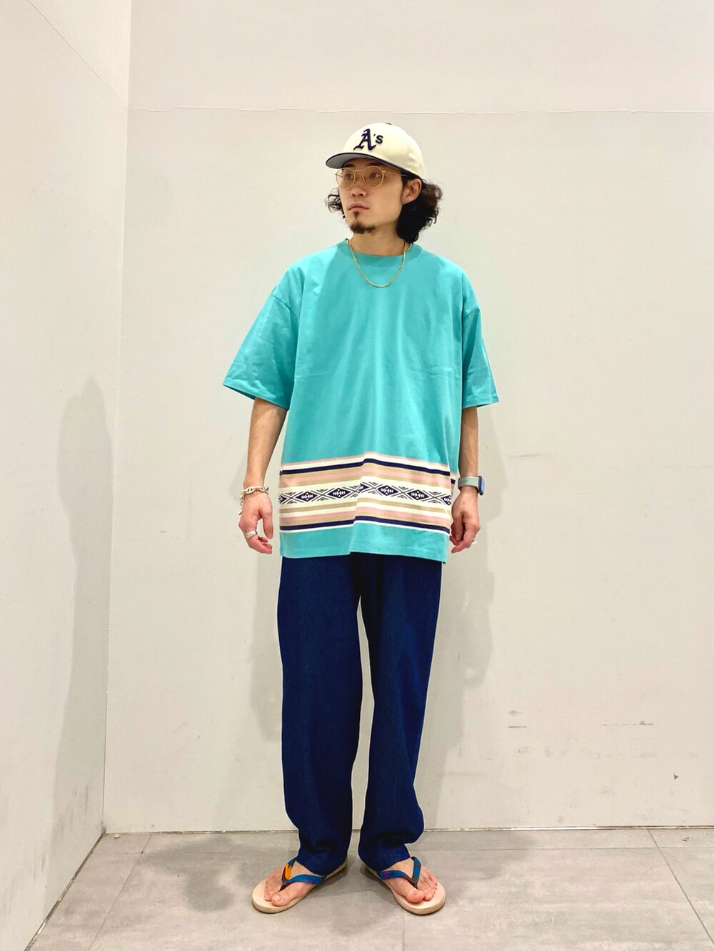 ホワイト系のシャツ/ブラウス、ブルー系のデニムパンツ、グリーン系のTシャツ/カットソーを着用したメンズの夏コーディネートの2枚目の写真